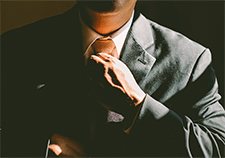 man in suit adjusting tie