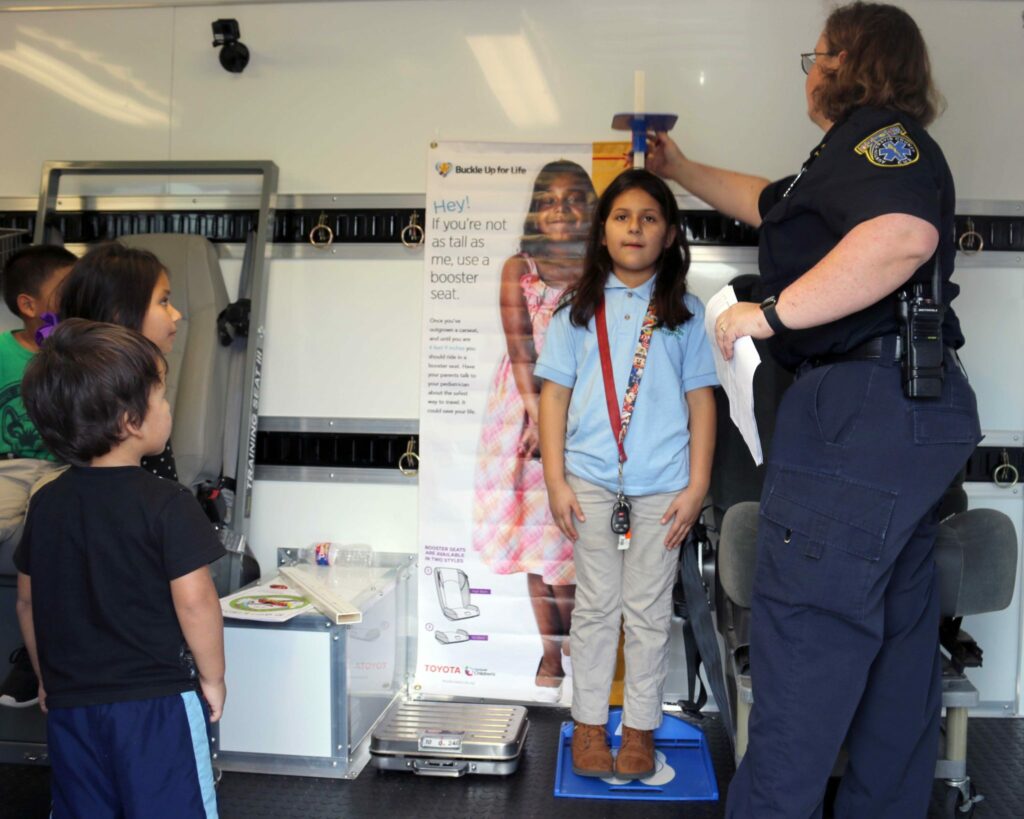 Children get their height measured inside the Austin-Travis County EMS Buckle Up for Life Safety Lab.