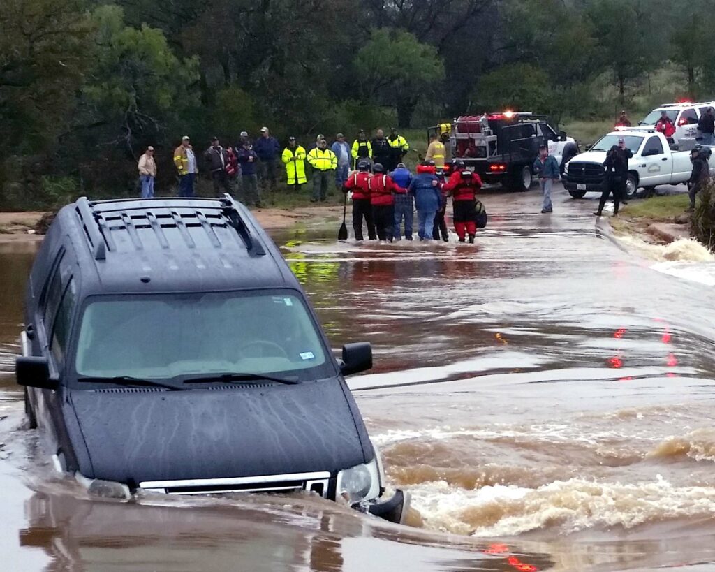 Rescue workers save a couple from a flooded low water crossing during a Central Texas storm.
