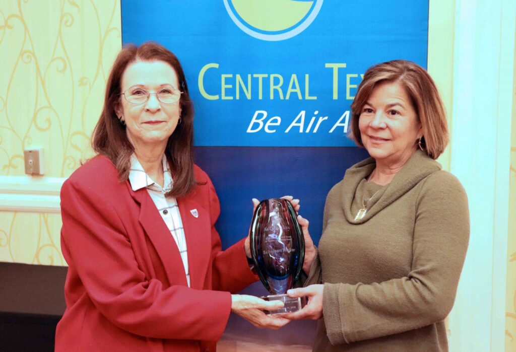 Clean Air Coalition Vice-Chair and San Marcos Mayor Jane Hughson (left) presents Scheleen Walker, Travis County Transportation and Natural Resources long-range planning director, with the Bill Gill Central Texas Air Quality Leadership Award.