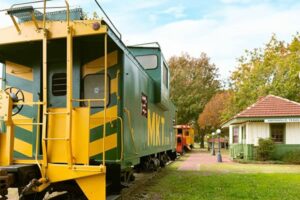A green and yellow train car in Smithville, Texas